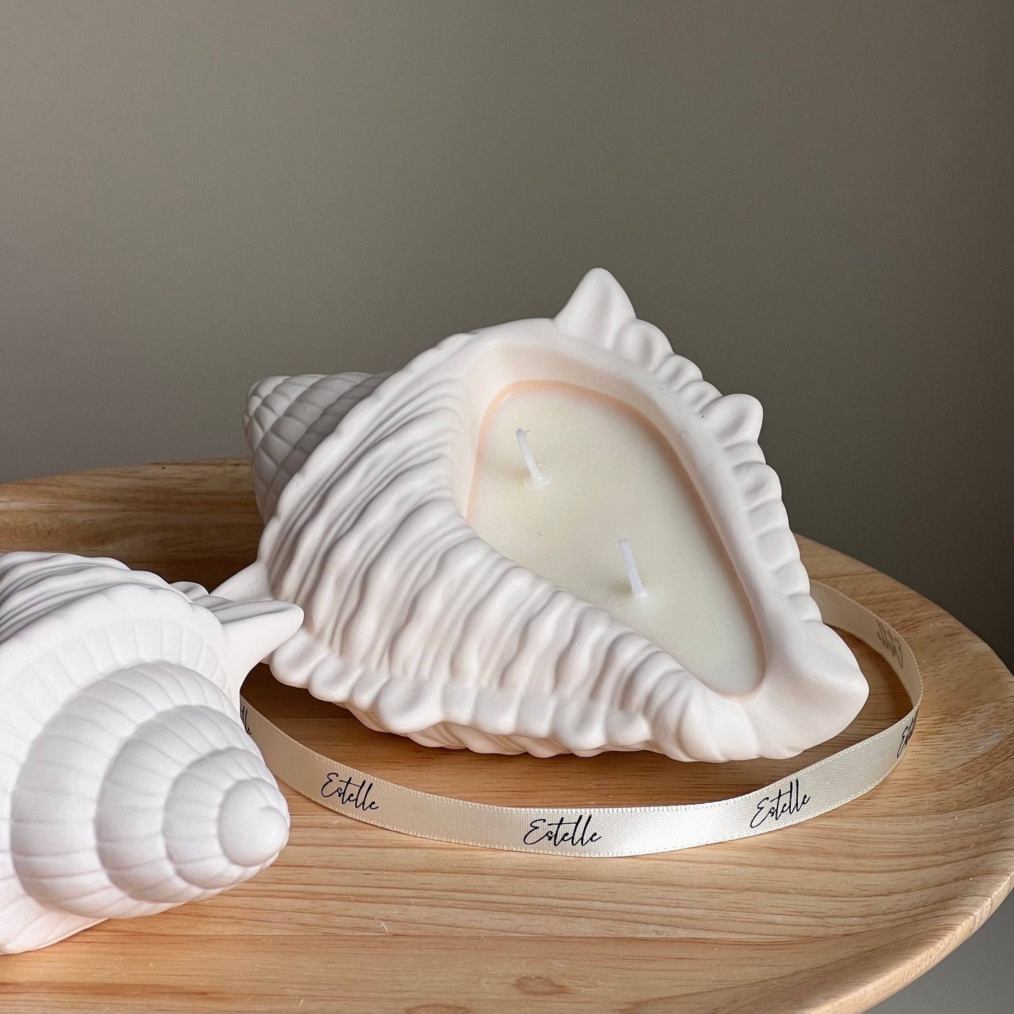 Bougie artisanale en cire de soja et coquillage, dans un contenant en Jesmonite. 